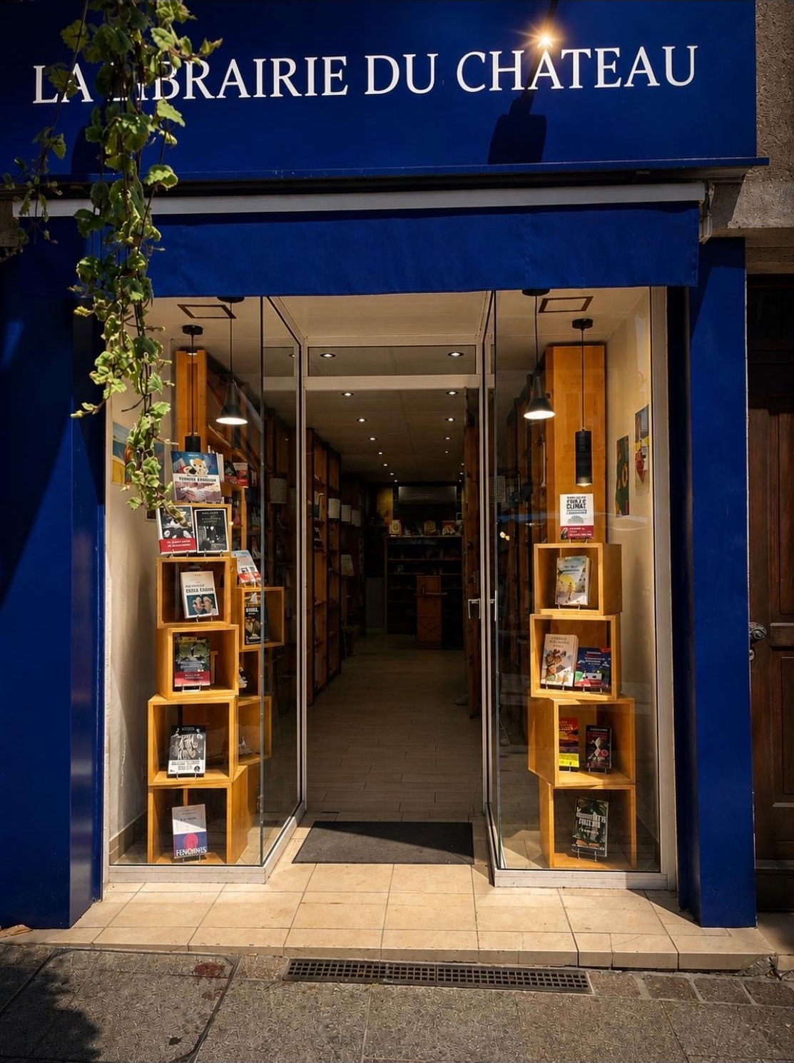 Façade bleue de La Librairie du Château, place du Marché